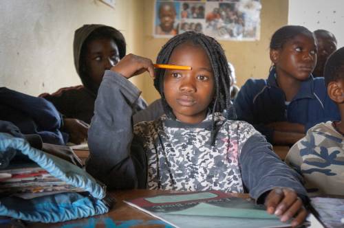 A girl deep in thought during a classroom exercise in Madagascar.