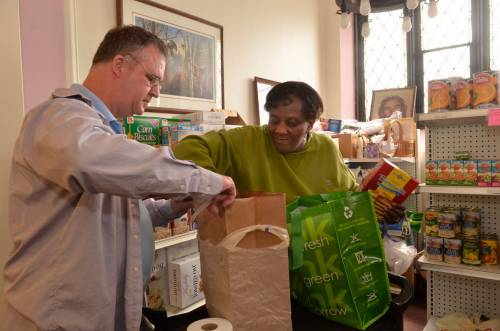 Keith Jakway, Geddes, NY, volunteer at the First United Presbyterian Church food pantry on West Genesee St in Syracuse, assisting Syracuse resident Bonnie Warren with her food needs.