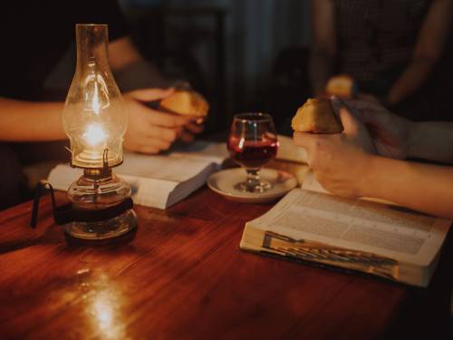 People at a table with Bibles, bread and wine