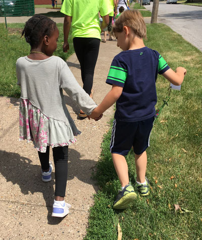 young children walking and holding hands